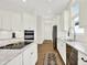 Bright kitchen features white cabinets, island with cooktop, stainless appliances, and natural light through the window at 11137 Peppermill Ln, Fishers, IN 46037
