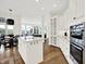 Bright kitchen features modern stainless steel appliances, white cabinets, and an island open to the living area at 11137 Peppermill Ln, Fishers, IN 46037