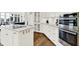 Open-concept kitchen showcasing a central island, stainless steel appliances, white cabinets, and a view of the living area at 11137 Peppermill Ln, Fishers, IN 46037