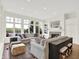 Light-filled living room with a fireplace, built-ins, hardwood floors, and large windows offering a view at 11137 Peppermill Ln, Fishers, IN 46037