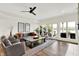 Open living room with wood floors, neutral decor, ceiling fan, and lake views at 11137 Peppermill Ln, Fishers, IN 46037
