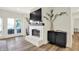 Bright living room with a painted brick fireplace, large window, and hardwood floors at 11137 Peppermill Ln, Fishers, IN 46037