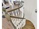 Staircase with hardwood steps and wood and white railings leading to lower level at 11137 Peppermill Ln, Fishers, IN 46037