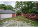 Spacious backyard featuring a detached garage, a storage shed, a lawn, and a wooden deck at 11218 Exchange St, Indianapolis, IN 46259