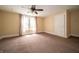 A light-filled bedroom with a ceiling fan, neutral walls, and plush carpet at 11218 Exchange St, Indianapolis, IN 46259