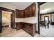 An efficient kitchen with brown cabinets, granite countertops and view to the dining room at 11218 Exchange St, Indianapolis, IN 46259