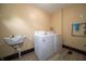 Bright laundry room featuring washer, dryer, sink, and durable floors at 11218 Exchange St, Indianapolis, IN 46259