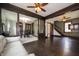 Open-concept living room and dining room featuring dark wood trim, hardwood floors and ceiling fans at 11218 Exchange St, Indianapolis, IN 46259