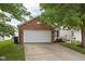 Charming single-Gathering home featuring a brick facade, a two-car garage, and mature trees enhancing curb appeal at 11620 Glenn Abbey Ln, Indianapolis, IN 46235