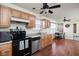 Functional kitchen with wooden cabinets, laminate counters, and black appliances, flowing into a dining area at 11620 Glenn Abbey Ln, Indianapolis, IN 46235