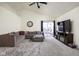 Comfortable living room with vaulted ceiling, plush carpeting, and sliding glass doors to the patio at 11620 Glenn Abbey Ln, Indianapolis, IN 46235