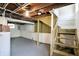 Unfinished basement with exposed wood ceiling and wooden stairs at 1411 N Linwood Ave, Indianapolis, IN 46201