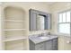 Bathroom with marble vanity, storage shelves, and a window at 1411 N Linwood Ave, Indianapolis, IN 46201
