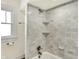 Bright bathroom featuring a tiled shower and tub combo with built-in shelves at 1411 N Linwood Ave, Indianapolis, IN 46201