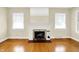 Bright living room featuring hardwood floors, a fireplace, and large windows allowing ample natural light at 1411 N Linwood Ave, Indianapolis, IN 46201
