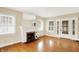 Bright living room with hardwood floors, a white fireplace, and a front door with glass panes at 1411 N Linwood Ave, Indianapolis, IN 46201