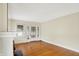 Sunlit living room with hardwood floors, a brick fireplace, and a glass-paneled front door at 1411 N Linwood Ave, Indianapolis, IN 46201