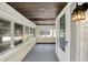 A sunroom with white walls, a wood ceiling, a gray floor, and plenty of natural light through multiple windows at 1411 N Linwood Ave, Indianapolis, IN 46201