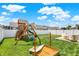 A fenced backyard boasts a large playset, sand box and patio, perfect for Gathering activities at 1460 Boots Trl, Greenfield, IN 46140