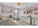 Bedroom room featuring wainscoting, a white crib, and floral wall decals at 1460 Boots Trl, Greenfield, IN 46140