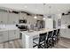 The kitchen features a center island with seating, pendant lighting, stainless steel appliances, and neutral paint at 1460 Boots Trl, Greenfield, IN 46140