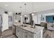 Open-concept kitchen with gray cabinets, a marble countertop island, and stainless steel appliances at 1460 Boots Trl, Greenfield, IN 46140