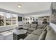 Bright living room with a gray sectional couch, grey coffee table, and view of the backyard through a large window at 1460 Boots Trl, Greenfield, IN 46140