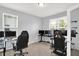 Bright office space with large windows, carpet flooring and multiple monitors creating the perfect home office at 1460 Boots Trl, Greenfield, IN 46140