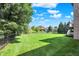 Well maintained backyard featuring a lush lawn, mature trees, and black metal fencing at 14737 Macduff Dr, Noblesville, IN 46062