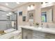 Well lit bathroom with double vanity, framed mirrors, and a tub shower with a glass door at 14737 Macduff Dr, Noblesville, IN 46062