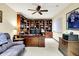Spacious home office with dark wood bookshelves, desk, ceiling fan, and blue sports memorabilia at 14737 Macduff Dr, Noblesville, IN 46062