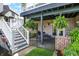 A cozy outdoor patio beneath a deck, featuring comfortable seating and lush hanging plants at 14737 Macduff Dr, Noblesville, IN 46062