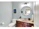 Charming powder room with stylish vanity, round mirror, and modern fixtures at 14737 Macduff Dr, Noblesville, IN 46062