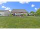 A well-manicured backyard with a wooden deck, patio set, green lawn, and fire pit at 15372 Black Gold Ct, Noblesville, IN 46060