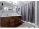 Well-lit bathroom with double vanity, hardwood floors, and a shower-tub with shower curtain at 15372 Black Gold Ct, Noblesville, IN 46060