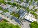 An aerial view showcases homes featuring backyard decks and well-maintained lawns, interspersed with commercial parking areas at 1610 N Alabama St, Indianapolis, IN 46202