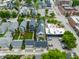 Aerial view of the backs of homes with gray roofs and small yards, along with other buildings, parking, and roads at 1610 N Alabama St, Indianapolis, IN 46202