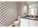 Stylish powder room featuring designer wallpaper and a sleek vanity with modern fixtures at 1610 N Alabama St, Indianapolis, IN 46202
