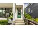 Inviting front porch with green front door, plants, and covered access at 1610 N Alabama St, Indianapolis, IN 46202