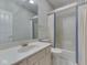 Bright bathroom with a large vanity and shower-tub combo with blue curtains at 1645 Oakmere Way, Greenwood, IN 46142