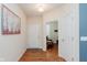 Hallway with hardwood floors, white doors, and a view to another room at 16573 Grappa Trl, Fishers, IN 46037