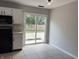 View of a kitchen with white cabinets, black appliances, tile floor and a view of the back yard at 187 Broadmoor Bnd, Pittsboro, IN 46167