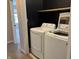 This laundry room has modern machines, overhead shelving, and a clean, organized layout for an efficient cleaning experience at 187 Broadmoor Bnd, Pittsboro, IN 46167