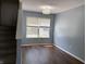 View of the open living room space with hardwood floors, neutral paint, a window and staircase at 187 Broadmoor Bnd, Pittsboro, IN 46167