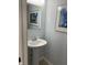 The powder room has a pedestal sink, a silver framed mirror and light blue walls at 187 Broadmoor Bnd, Pittsboro, IN 46167