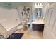Bathroom with a white tiled shower, bathtub, and toilet with colorful decor on display at 19824 Atwater Ave, Sheridan, IN 46069