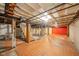 Unfinished basement with exposed ceiling and beams and orange tile floor at 2035 W Kessler Blvd N Dr, Indianapolis, IN 46222