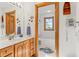 Bathroom with wood cabinets, a large mirror, and a bathtub in a separate room at 2320 Whispering Way, Indianapolis, IN 46239
