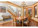Charming dining room with hardwood floors, wainscoting, a wooden table, and staircase at 2320 Whispering Way, Indianapolis, IN 46239