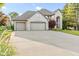 Two story brick home with a three-car garage and long concrete driveway at 2320 Whispering Way, Indianapolis, IN 46239